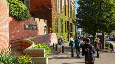 Students walking on campus past Firth Court